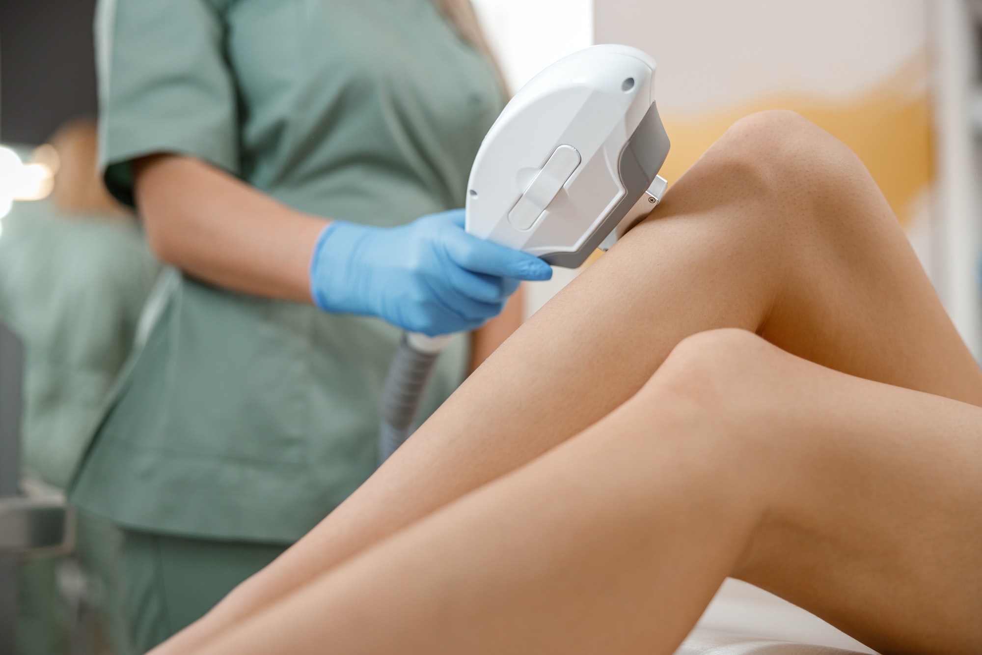 Closeup of legs laser photo epilation with ipl machine in beauty salon